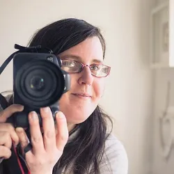 Cheryl, the photographer behind Life is Peachy, smiling behind her camera