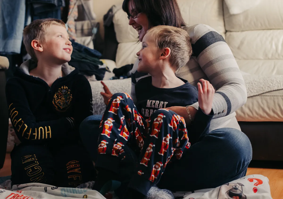 A family laughing together on the sofa at home